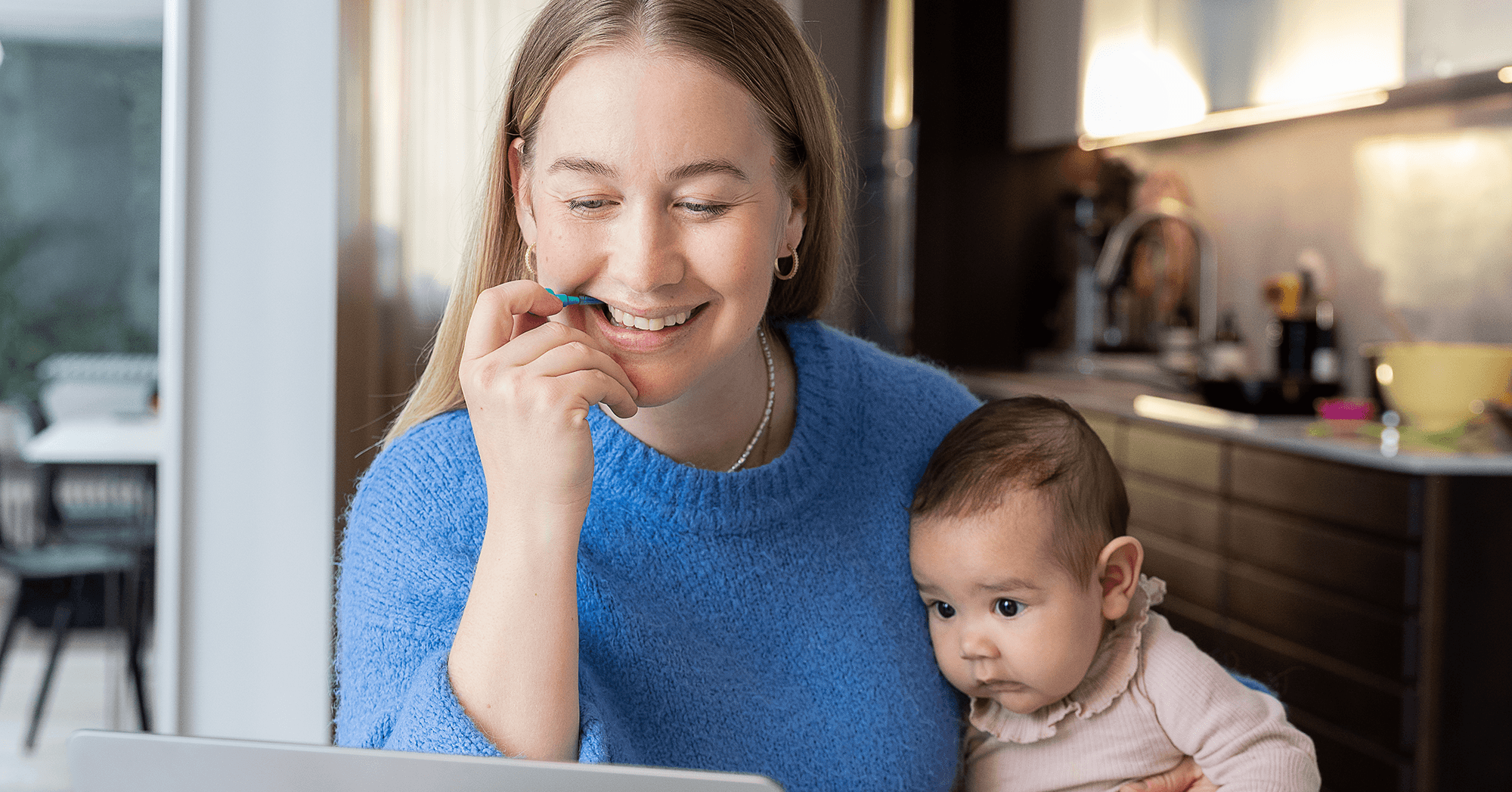A multitasking mom holding her baby on one arm and cleaning between her teeth at the same time