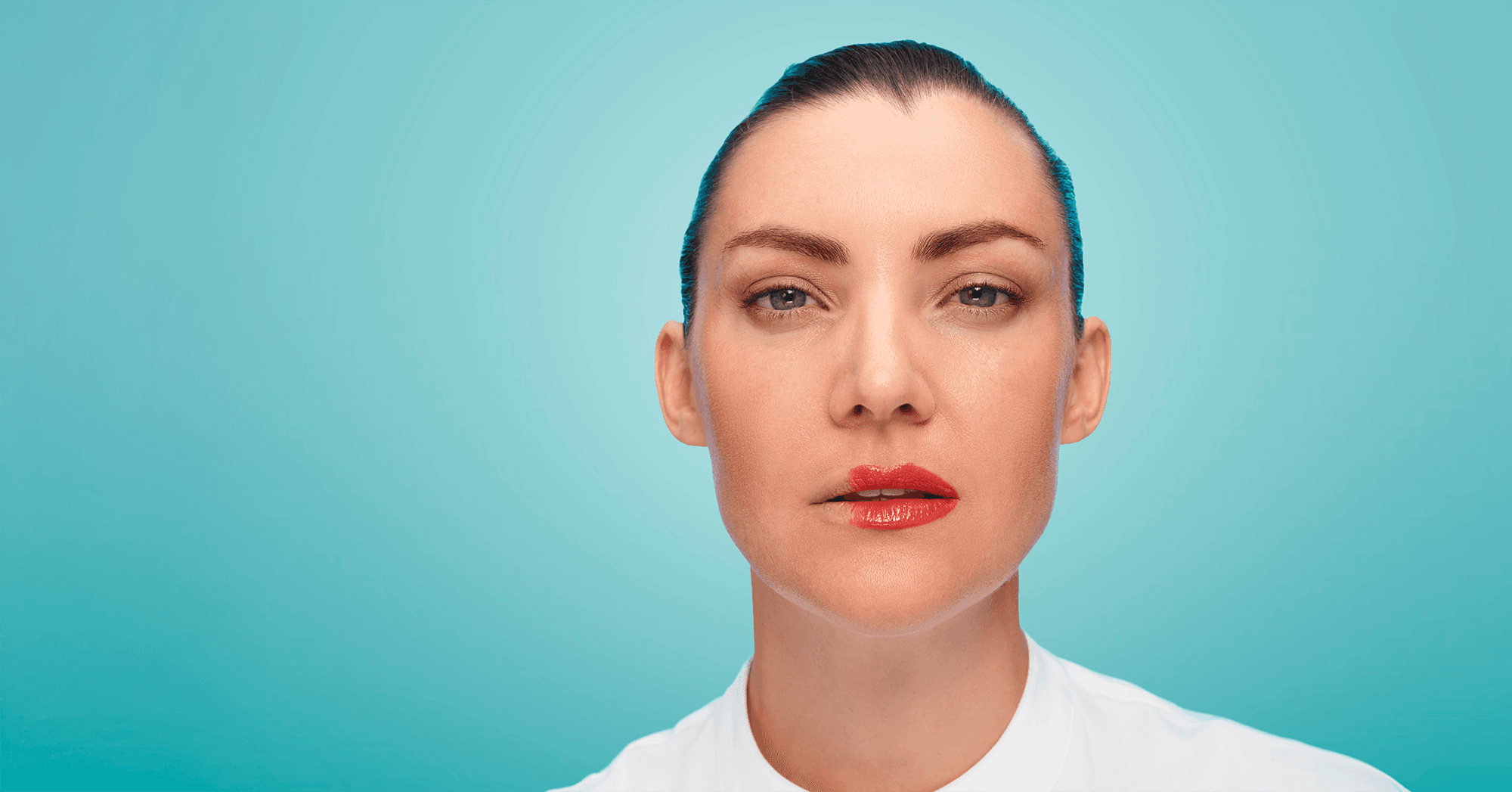 Blue background, a woman in a white shirt and red lipstick is looking into the camera